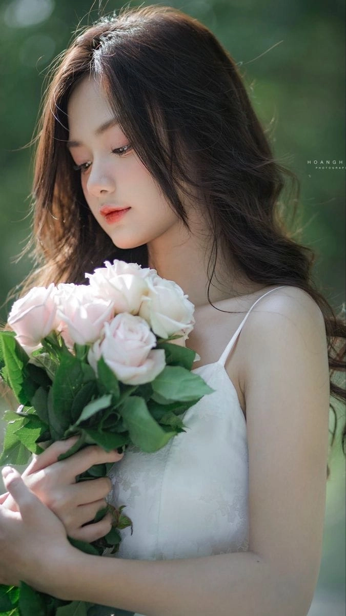 Cô gái trong máu áo trắng thướt thabên hoa sen