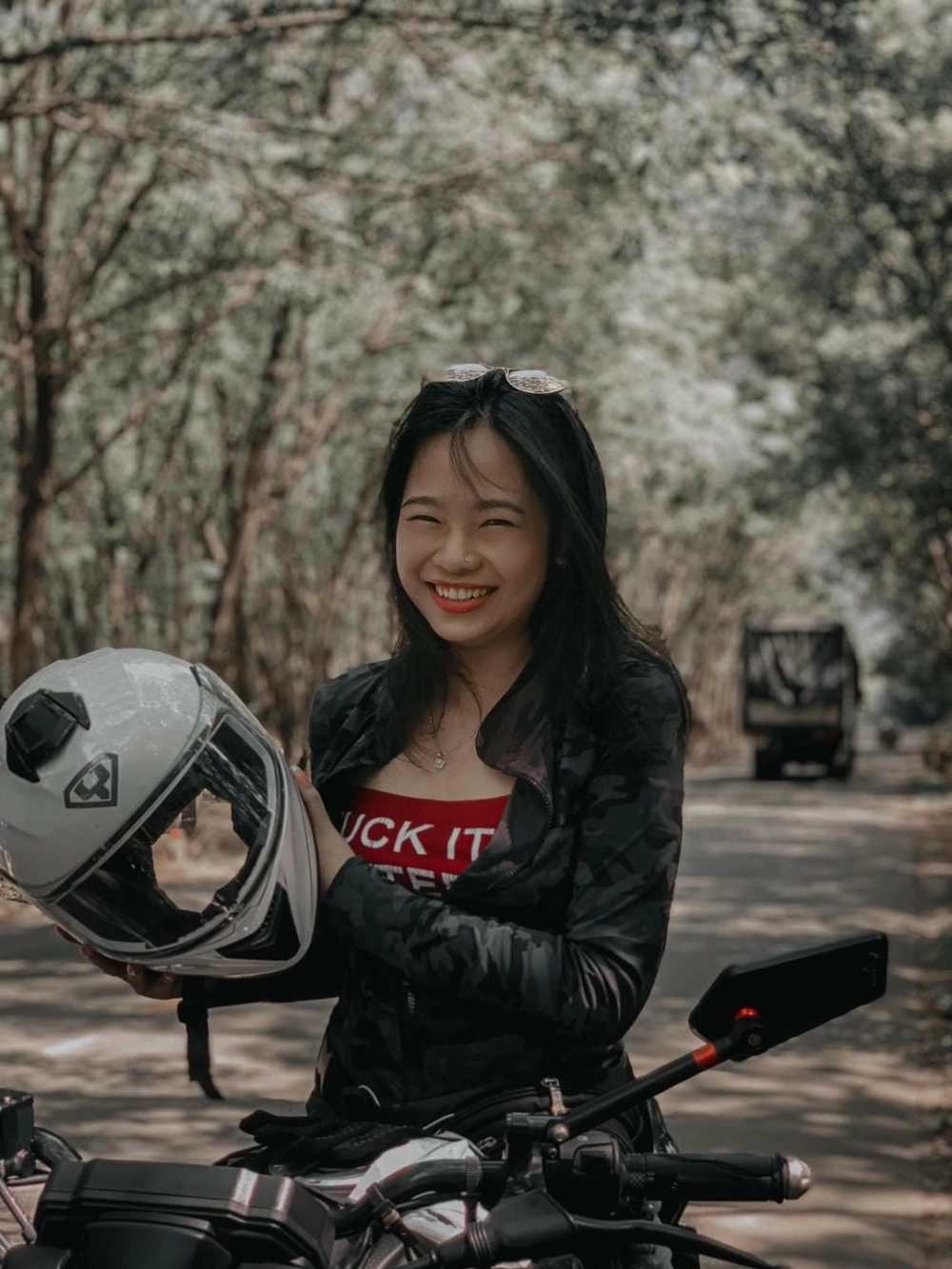 Một cô gái đi xe máy trong thành phố về đêm