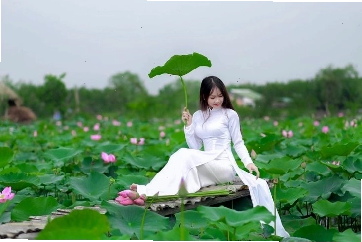 Áo dài trắng thướt tha với hoa sen tạo nên bức ảnh đầy ấn tượng