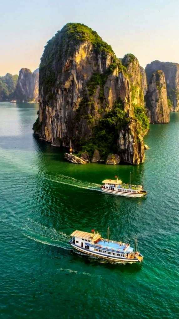 Du thuyền nhỏ giữa vịnh biển xanh và núi đá
